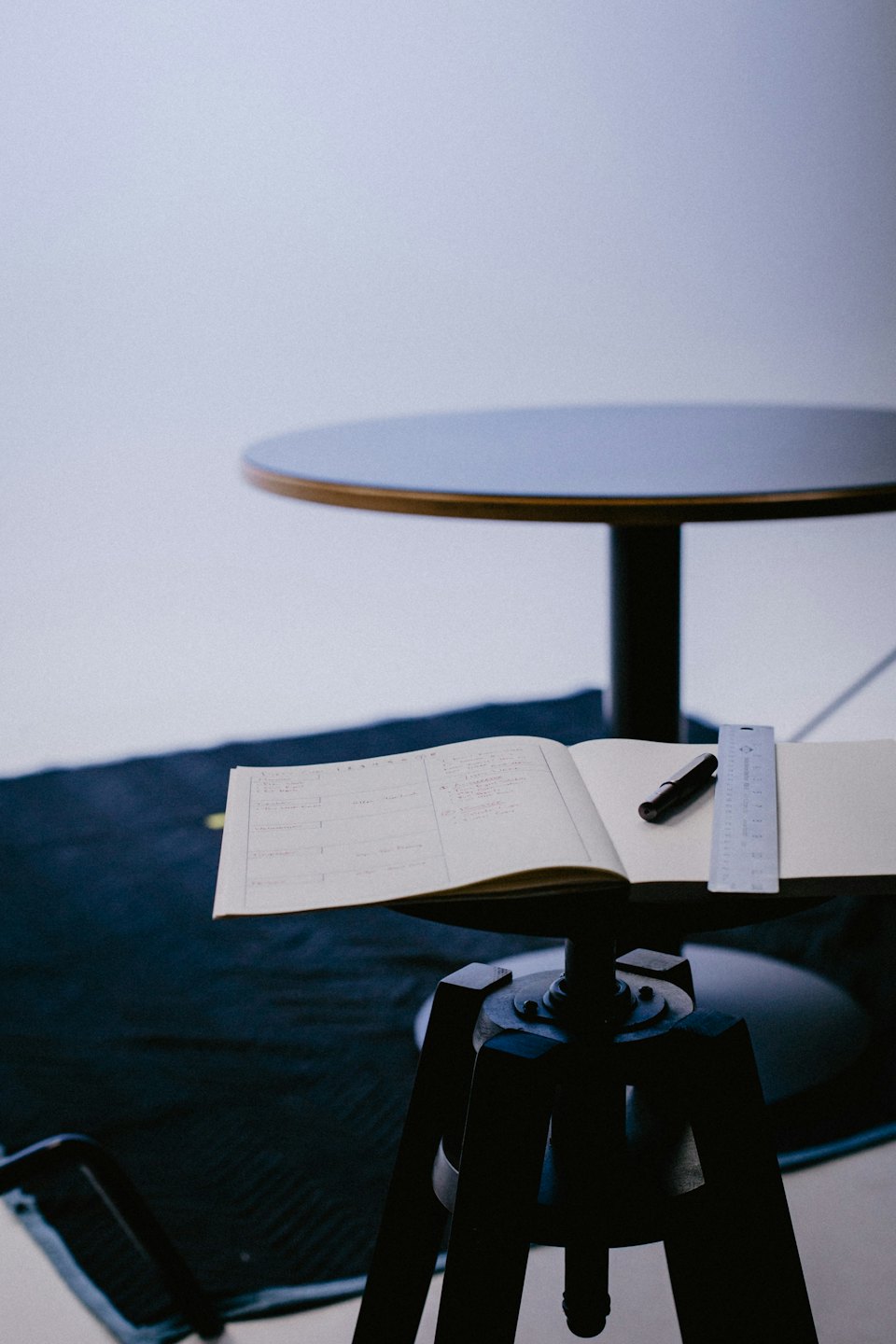 Notebook, pen, and ruler on a tripod.