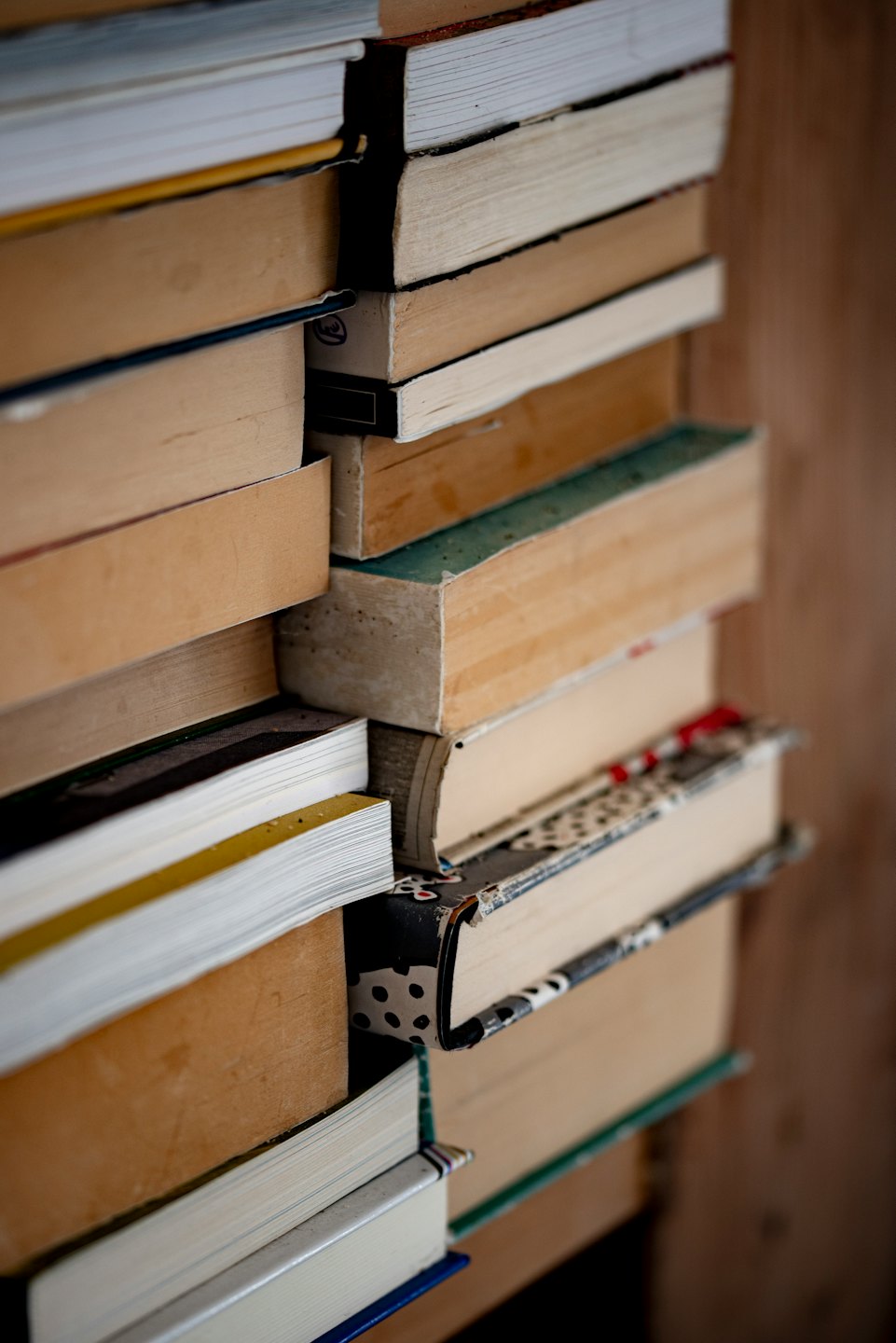 Stacks of old and new books piled indoors.